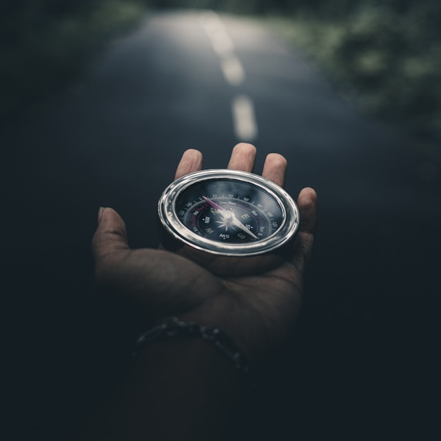 An open palm holding a compass with a road stretching ahead, representing guidance and finding your path in psychotherapy